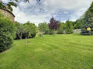 um grande quintal com relva verde e árvores em Les Grandes Vignes em Saint-Étienne-sous-Bailleul