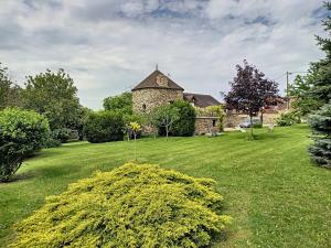 an old stone church in a field of grass at Les Grandes Vignes in Saint-Étienne-sous-Bailleul