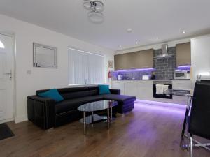 a living room with a couch and a table at Live in Leeds Greenhill Bungalows in Leeds