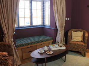 a room with a bench and a table and a window at The Lodge at Hemingford Grey House in Hemingford Grey