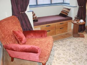 a living room with a chair and a bench at The Lodge at Hemingford Grey House in Hemingford Grey