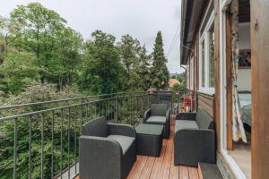 a balcony with chairs and a view of trees at Duszniki-Zdrój Przytulny Apartament z Tarasem in Duszniki Zdrój