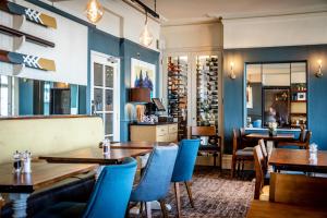 a restaurant with wooden tables and blue chairs at The Marine in Whitstable