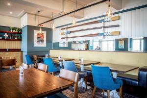a restaurant with wooden tables and blue chairs at The Marine in Whitstable