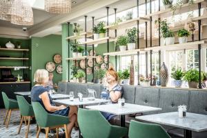 two women sitting at tables in a restaurant at The Marine in Whitstable