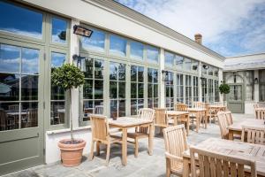 an outdoor patio with tables and chairs and windows at The Marine in Whitstable