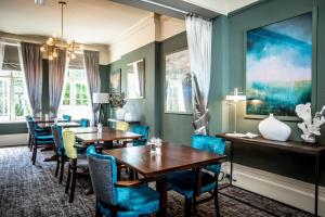 a dining room with two tables and blue chairs at The Marine in Whitstable