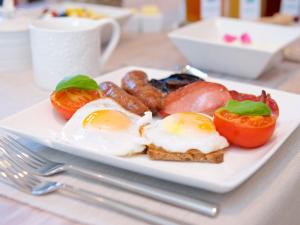 a plate of breakfast food with eggs sausage and tomatoes at Hale House in Wendover