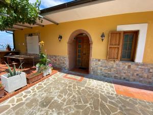 a house with a stone walkway leading to the front door at B & B Il Campanile in Perdifumo