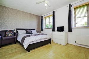 a bedroom with a bed, desk, chair and window at Harlinger Lodge Annexe in London