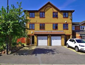 a white car parked in front of a house at Harlinger Lodge Annexe in London