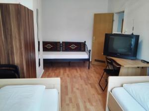 una pequeña sala de estar con TV y cama en Harsdörffer Apartment, en Núremberg