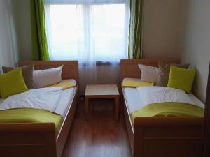 two beds in a small room with a window at Harsdörffer Apartment in Nürnberg