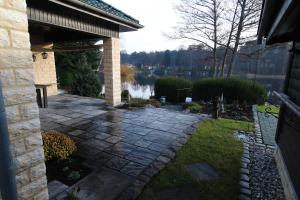 a stone patio with a view of a lake at KAMA Ferienhäuser Haus Kathrin in Wendisch Rietz