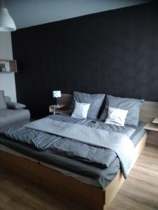 sypialnia z dużym łóżkiem z czarną ścianą w obiekcie KarosPool Apartman w Zalakaros