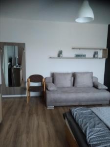 a living room with a couch and a chair at KarosPool Apartman in Zalakaros