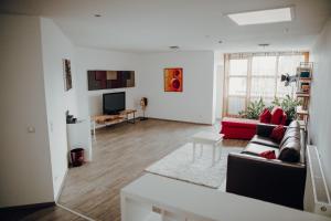 ein Wohnzimmer mit einem Sofa und einem TV in der Unterkunft Parkhotel Brunauer in Salzburg