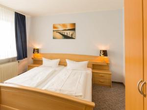 ハイリゲンハーフェンにあるJust sleep, Heiligenhafenのベッドルーム1室(ベッド1台、ランプ2つ付きのデスク付)