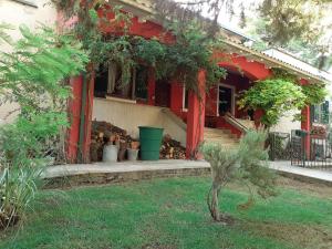 een rood huis met een veranda met planten bij Villa con Piscina in Umbria in Foligno