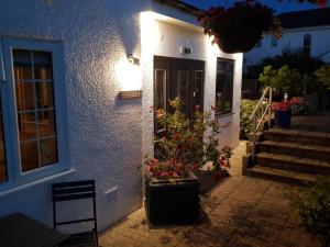 a white house with a door with flowers on it at Hensleigh House in Charmouth