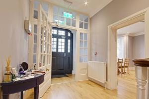 a hallway with a black door and a dining room at Highfield Bed & Breakfast in Lymington