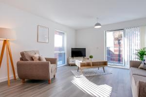 a living room with a couch and a tv at Hilltop Serviced Apartments- Northern Quarter in Manchester
