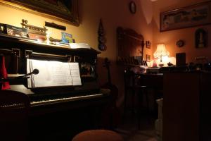 un vecchio pianoforte in una stanza con una lampada di B&B Bruno a Cosenza