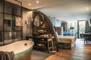 a bath room with a tub and a sink at Alpin Garden Luxury Maison - Adults Only in Ortisei