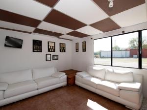 a living room with white couches and a large window at Hotel La Rinconada Tequisquiapan in Tequisquiapan