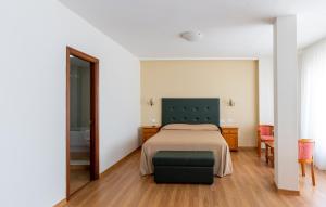 a bedroom with a bed with a green headboard and a mirror at Hotel Nautilus in Raxó