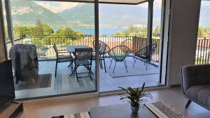 a living room with a balcony with a table and chairs at Appartement Laudon in Sévrier