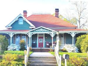 a blue house with a red door at Holly House of Hamilton in Hamilton