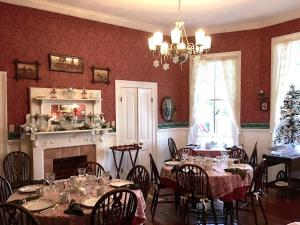 Holly House of Hamilton في Hamilton: غرفة طعام مع طاولات وكراسي ومدفأة