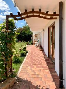 a brick walkway leading to a house with a pergola at Gemütliche Ferienwohnung im Herzen des Schwarzwaldes in Niedereschach