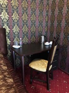 a chair and a table in a room at Garden Hall in Ternopil