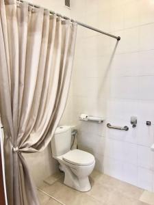 a white toilet sitting next to a shower curtain at Garden Hall in Ternopil