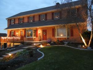 a brick house with lights in the yard at Homestead Lodging in Smoketown