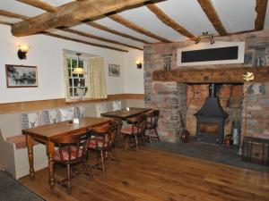 a dining room with two tables and a fireplace at The Hood Arms in Kilve