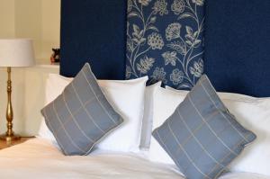 a bed with two pillows on top of it at The Hood Arms in Kilve