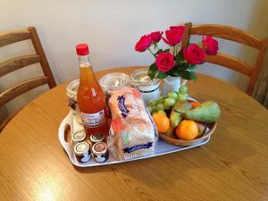 a table with a bottle of drink and a basket of fruit at Hook Farm Cottages in Royal Wootton Bassett
