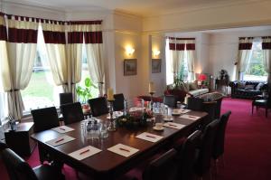 a dining room with a table and chairs and a room with a couch at Hookwood Lodge in Horley