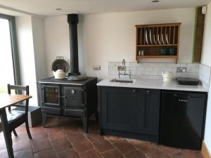 a kitchen with a black stove and a sink at Horizon Barn in Market Rasen