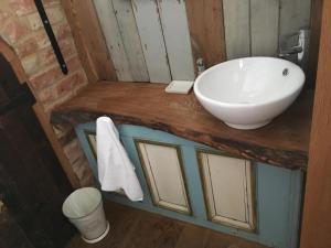ein Badezimmer mit einem weißen Waschbecken auf einer Holztheke in der Unterkunft Horizon Barn in Market Rasen