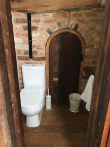 a bathroom with a toilet in a brick wall at Horizon Barn in Market Rasen