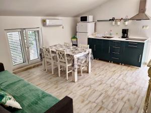 a kitchen with a table and chairs in a room at Appartements Dominique, with private terrace in Supetarska Draga