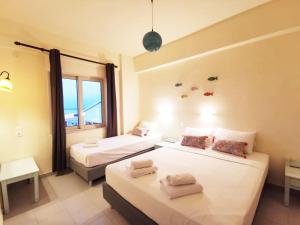 una camera d'albergo con due letti e una finestra di Aqua Maris a Hersonissos