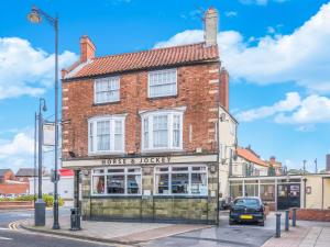 un edificio en una calle con un coche aparcado delante en The Horse & Jockey, en Gainsborough