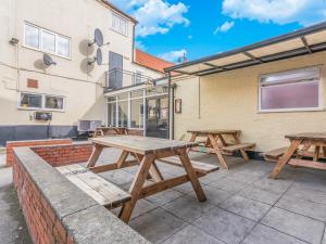 un grupo de mesas de picnic en un patio en The Horse & Jockey, en Gainsborough