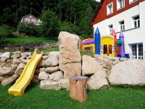 un parque infantil con tobogán y pared de roca en Apartmány pod Mariánskými schody, en Desná