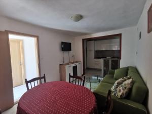 uma sala de estar com um sofá verde e uma mesa em Apartmani Franceska em Bol